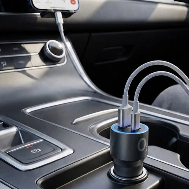O₂ autonabíječka zapojená v zásuvce automobilu se dvěma připojenými nabíjecími kabely.